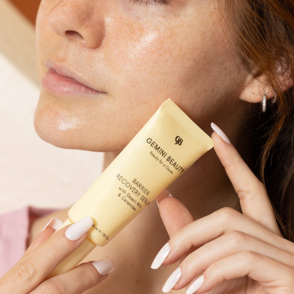 Woman holds  barrier recovery serum with desert milk and ceramides near her face